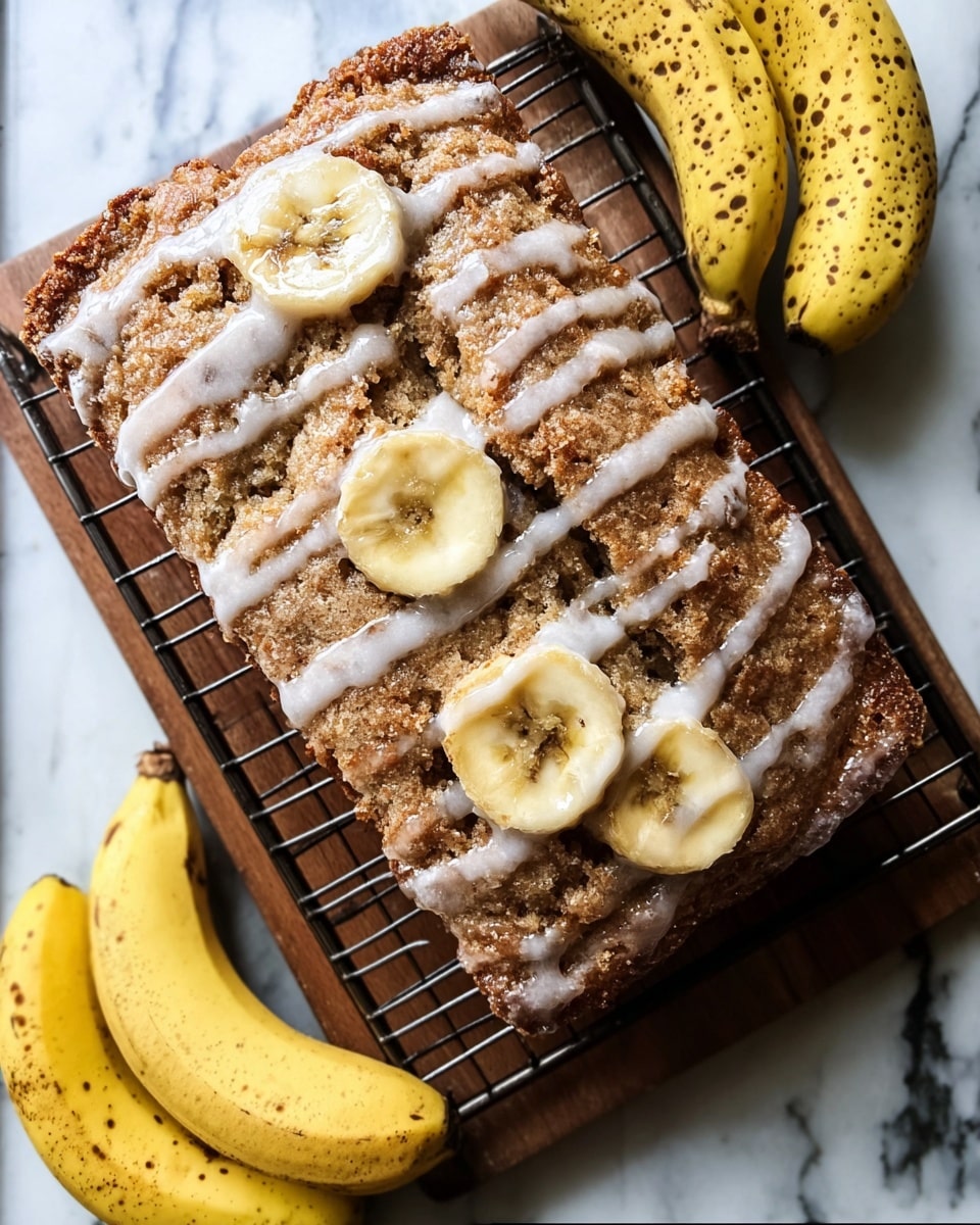 A slice of banana bread is shown from a top view, resting on a wire rack over a wooden board, all placed on a white marbled surface. The banana bread has a light brown, textured crust with three visible slices of banana embedded on top. It is drizzled with a white glaze that spreads unevenly across the surface, following the ridges of the bread. Around the edges of the wire rack, there are three whole yellow bananas with brown spots, lying on the white marbled background. Photo taken with an iphone --ar 4:5 --v 7