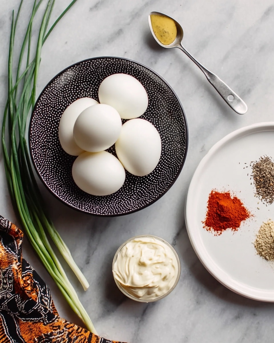 The image shows six white boiled eggs placed in a small bowl with a black dotted pattern, positioned on a white marbled background. To the right, there is a clean white plate holding three small piles of spices — white salt, black pepper, and red paprika — arranged in a triangle, with a teaspoon containing yellow mustard resting on the plate overlapping the spices. Below the plate, a metal measuring spoon filled with creamy white mayonnaise is set on the marbled surface. Long green chive stalks are placed on the left side of the eggs, and a fabric with a black and orange pattern partially appears at the bottom corner. photo taken with an iphone --ar 4:5 --v 7