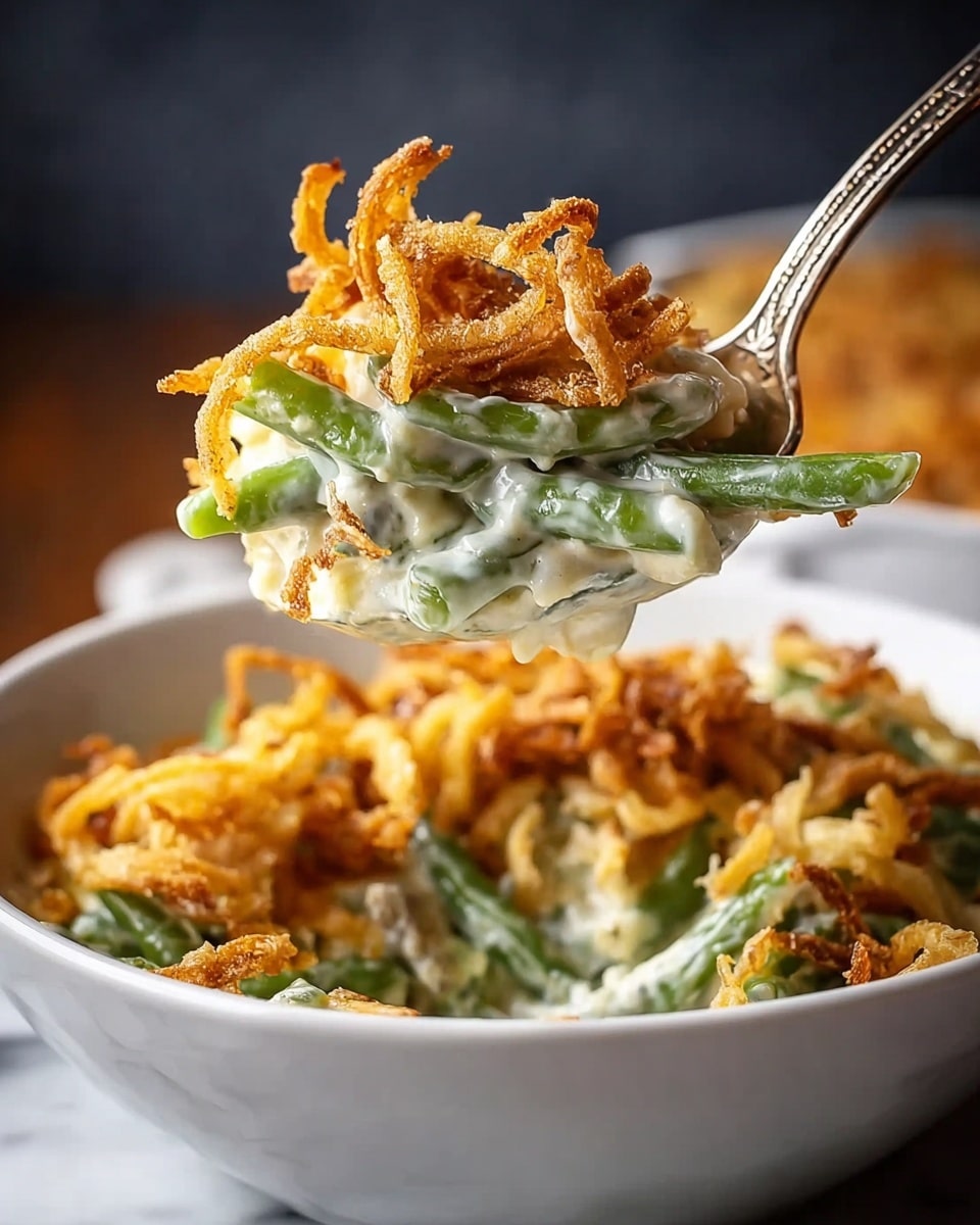 A close-up view of a spoon holding a creamy green bean casserole with three visible layers: at the bottom, thick white creamy sauce mixed with green beans; in the middle, bright green beans coated in the sauce; and on top, golden brown crispy fried onion strings with a rough and crunchy texture. The spoon is lifted over a white bowl filled with more of the casserole, showing a background of the same creamy green bean mixture and fried onions. The setting has a blurred dark background to highlight the dish, placed on a white marbled surface. Photo taken with an iphone --ar 4:5 --v 7