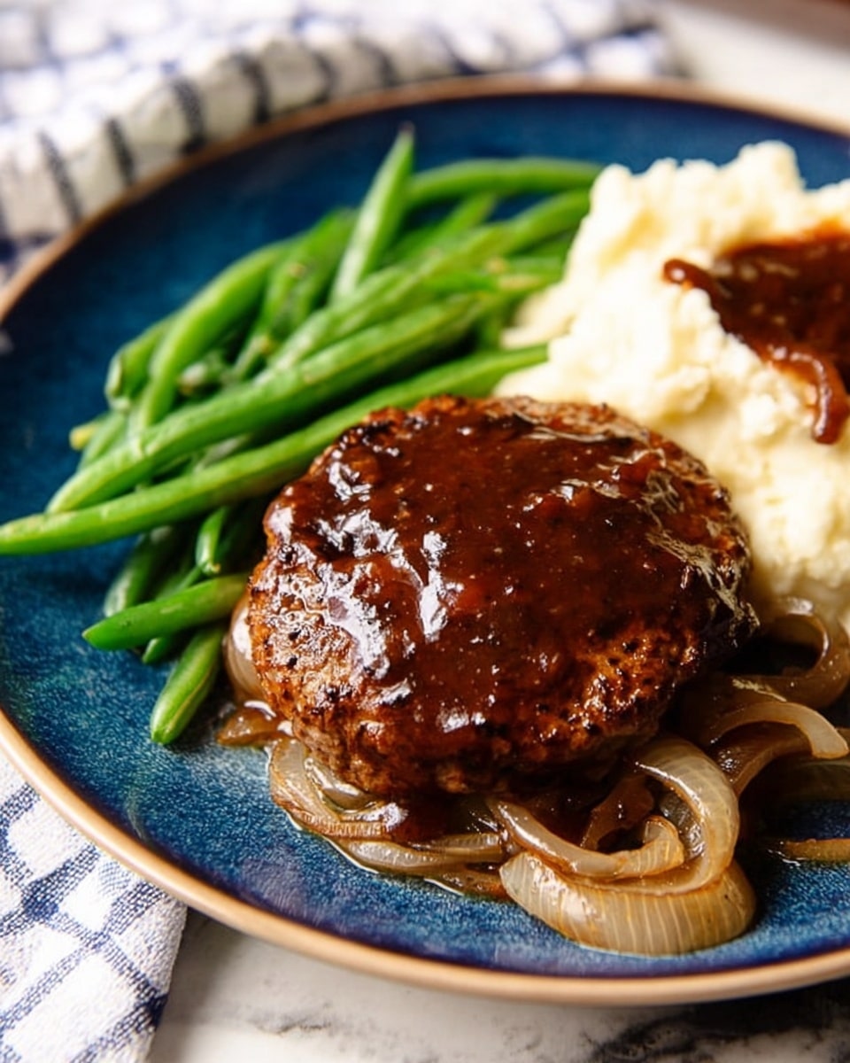 A blue plate holds a shiny brown patty covered in dark brown sauce, resting on a bed of cooked onions with visible texture and a few caramelized spots. To the left side of the patty, there are bright green cooked green beans with a smooth surface. Behind the patty, a scoop of creamy mashed potatoes topped with a small amount of the same dark brown sauce is visible. The plate is placed on a white marbled surface with a white and blue checkered cloth nearby. Photo taken with an iphone --ar 4:5 --v 7