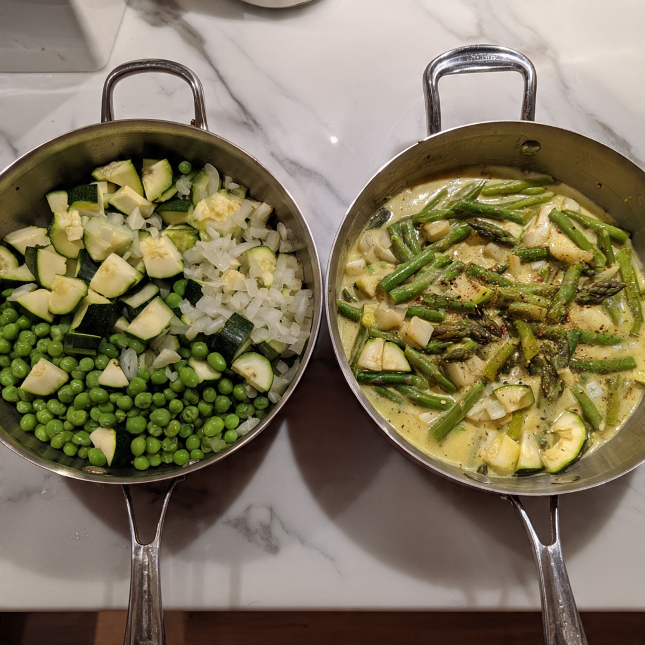 The image shows two silver pans from above, each with food inside, placed on a white marbled surface. The left pan contains chopped green vegetables including sliced zucchini, green peas, and chopped asparagus, mixed with diced white onion and minced garlic, all evenly spread in the pan. The right pan shows the same vegetables now covered in a light greenish creamy sauce, with visible slices of zucchini and specks of seasoning floating on top. Both pans have two sturdy side handles. Photo taken with an iphone --ar 4:5 --v 7